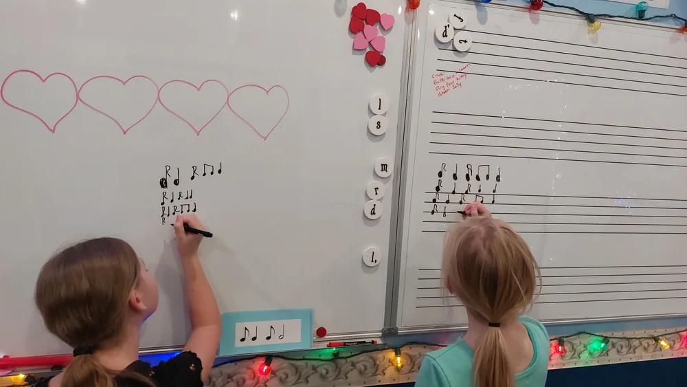 Students writing music at the whiteboard